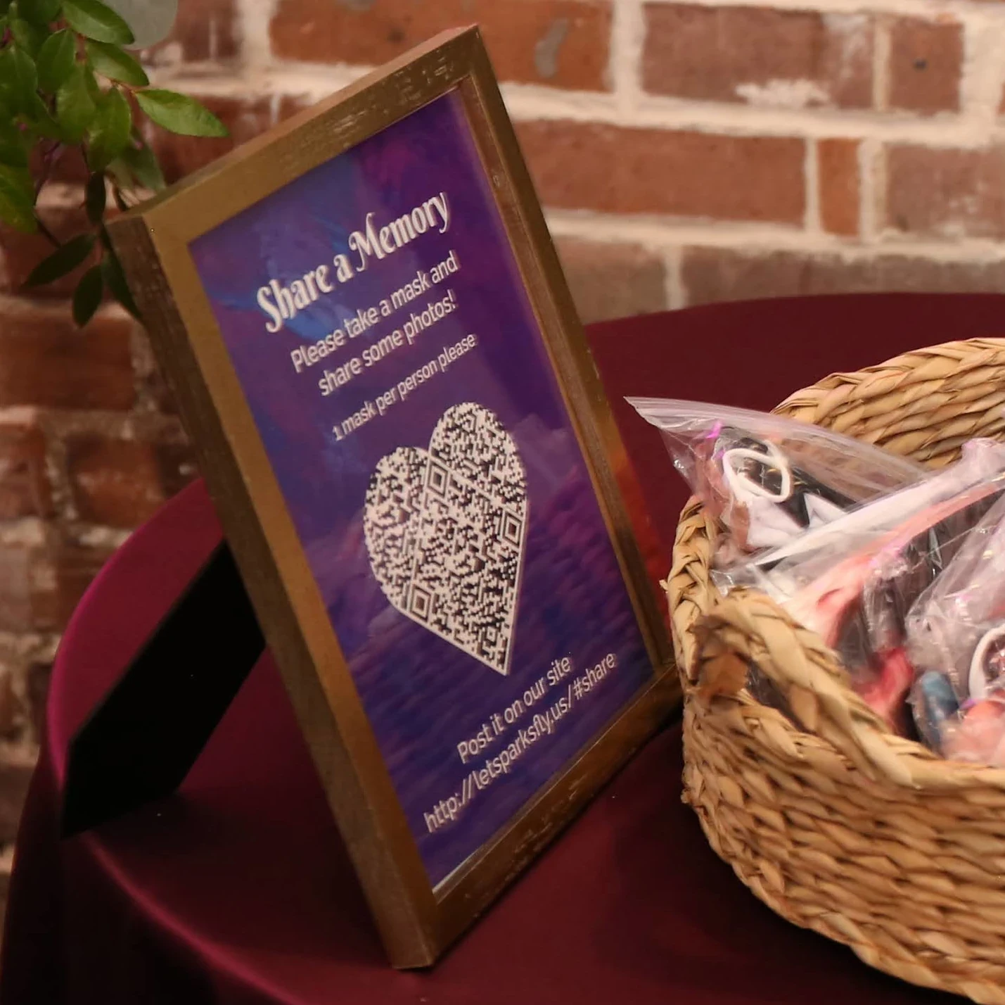 Framed “Share a Memory” sign with a heart-shaped QR code encouraging guests to post photos and messages